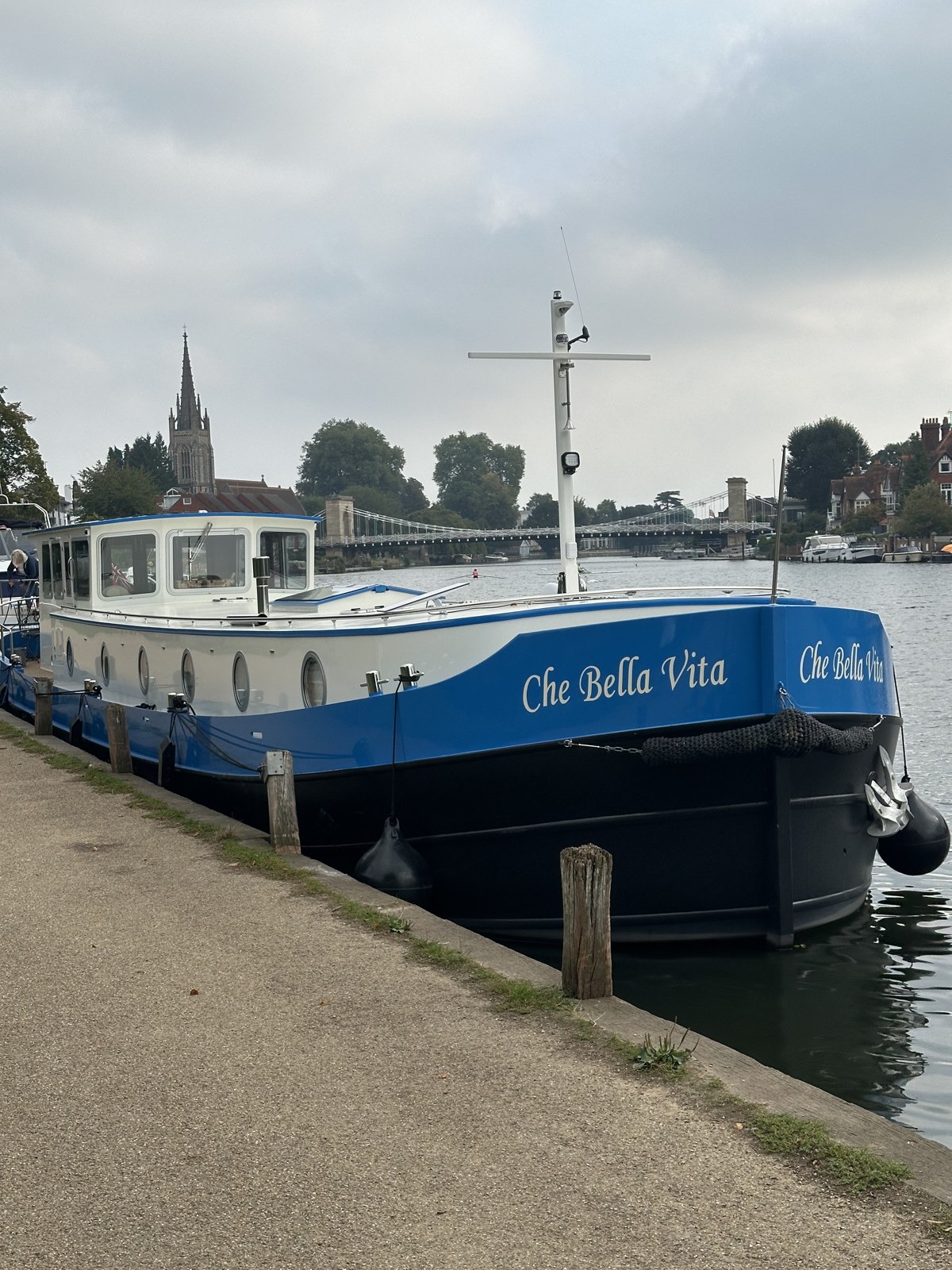 Che Bella Vita moored at night at Marlow with the suspension bridge and church spire behind