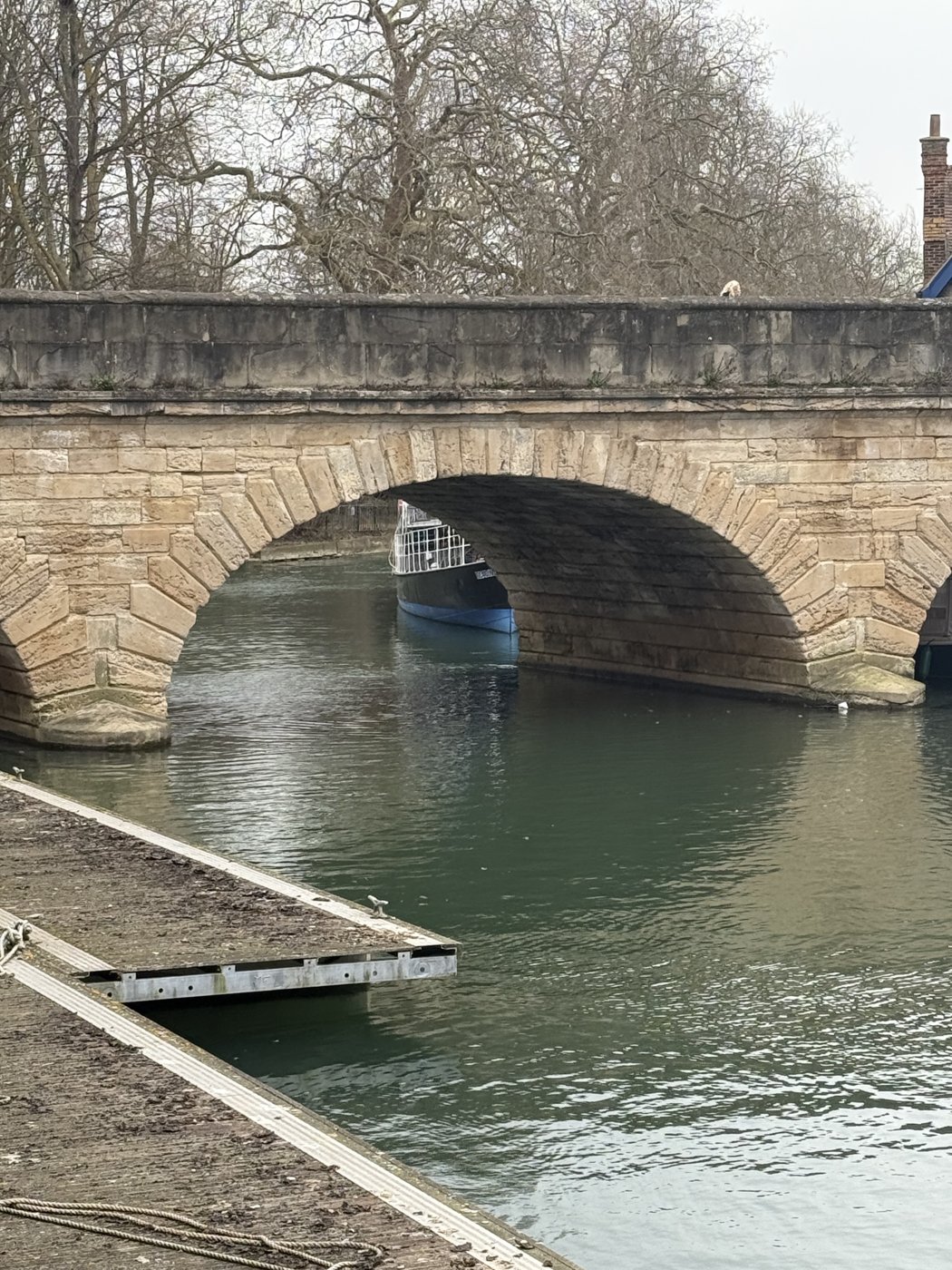 The stone arch of Folly Bridge with a boat moored beneath it