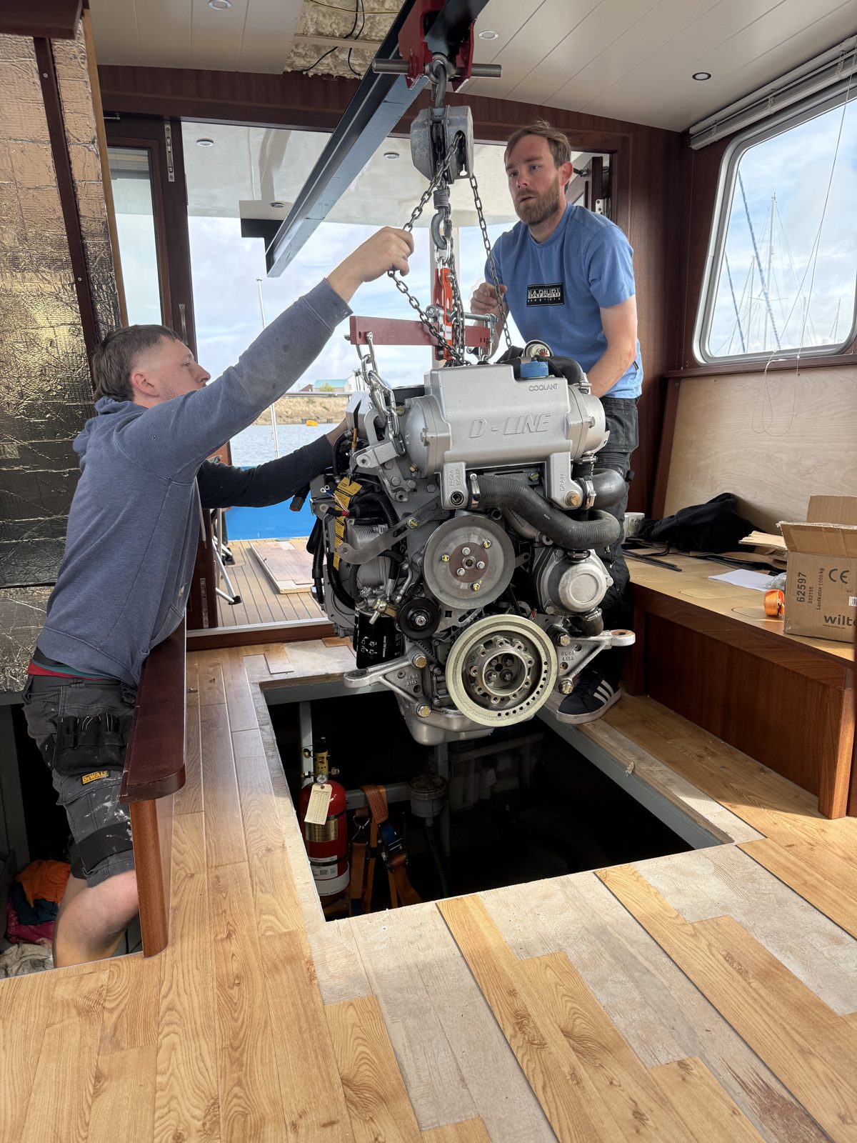 Josh and Woz lowering the new engine through the wheelhouse floor