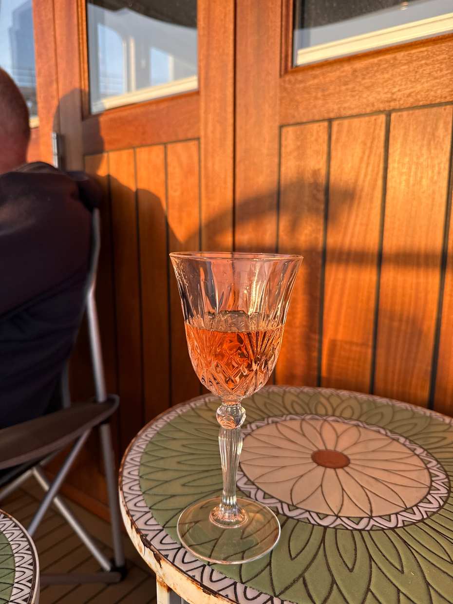 A glass of wine on deck at sunset in Oxwich Bay
